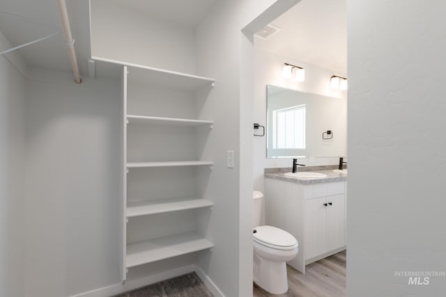 4403 N Magical Creek Ave, Meridian, ID 83646 - bathroom featuring toilet, vanity, wood finished floors, and visible vents