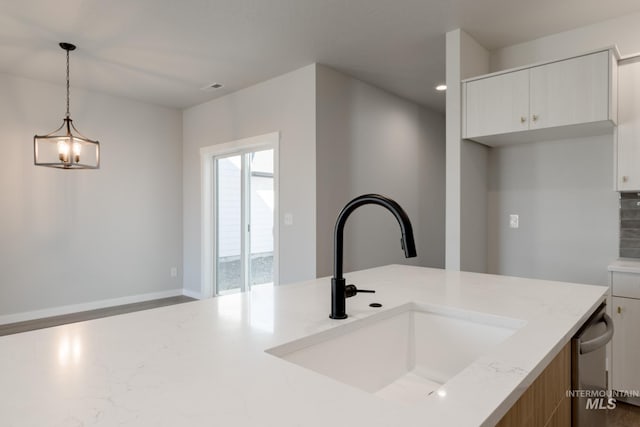 4403 N Magical Creek Ave, Meridian, ID 83646 - kitchen with light stone counters, visible vents, a sink, pendant lighting, and white cabinetry