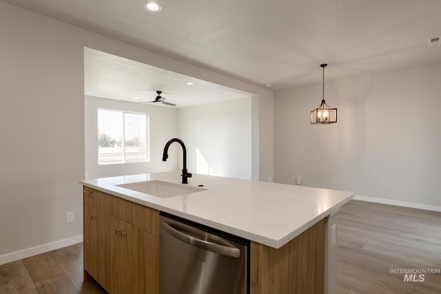 4403 N Magical Creek Ave, Meridian, ID 83646 - kitchen with an island with sink, wood finished floors, stainless steel dishwasher, a sink, and baseboards