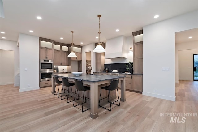 9989 W Bouvardia St, Star, ID 83669 - kitchen with double oven, dark countertops, custom exhaust hood, recessed lighting, and a breakfast bar