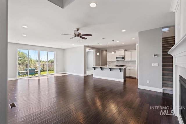 3631 S Pheasant Tail Way, Boise, ID 83716 - unfurnished living room with ceiling fan, dark wood-type flooring, baseboards, recessed lighting, and a fireplace