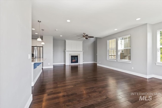 3631 S Pheasant Tail Way, Boise, ID 83716 - unfurnished living room featuring a ceiling fan, recessed lighting, dark wood-type flooring, baseboards, and a fireplace