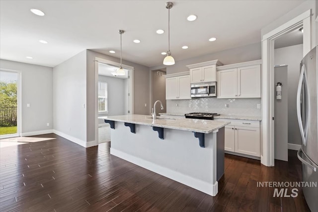 3631 S Pheasant Tail Way, Boise, ID 83716 - kitchen with appliances with stainless steel finishes, a sink, recessed lighting, decorative backsplash, and a kitchen bar