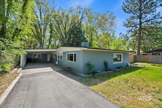 single story home with a front lawn, aphalt driveway, fence, stucco siding, and an attached carport