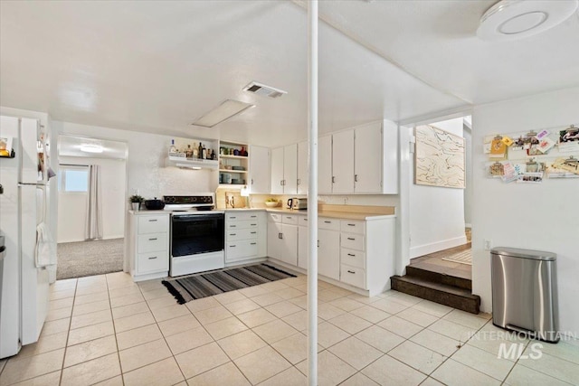 kitchen with light tile patterned flooring, white appliances, light countertops, white cabinetry, and visible vents