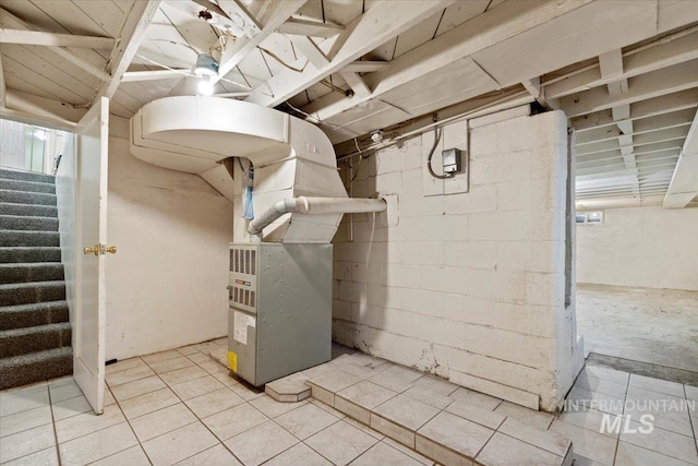 unfinished below grade area with stairs, light tile patterned flooring, and heating unit