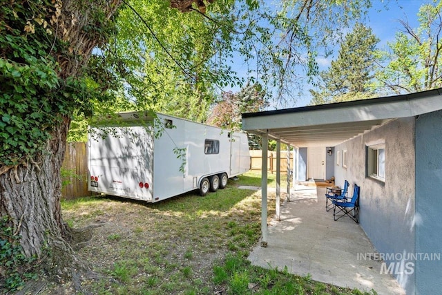 view of yard featuring a storage shed, fence, and an outbuilding