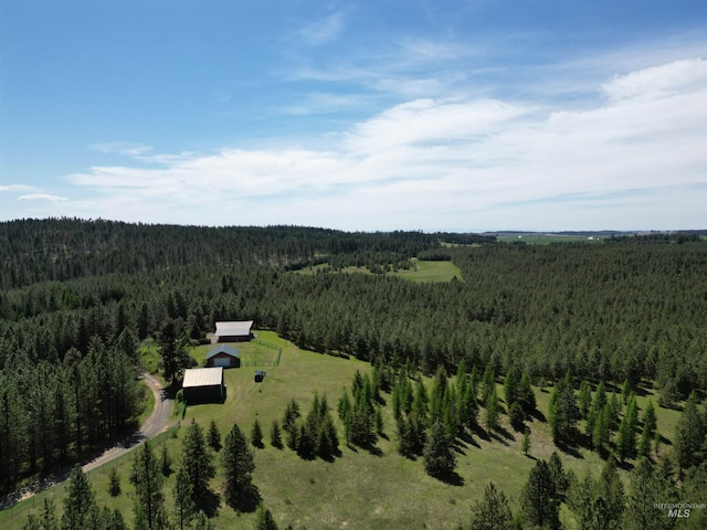 aerial view of property and surrounding area featuring a forest