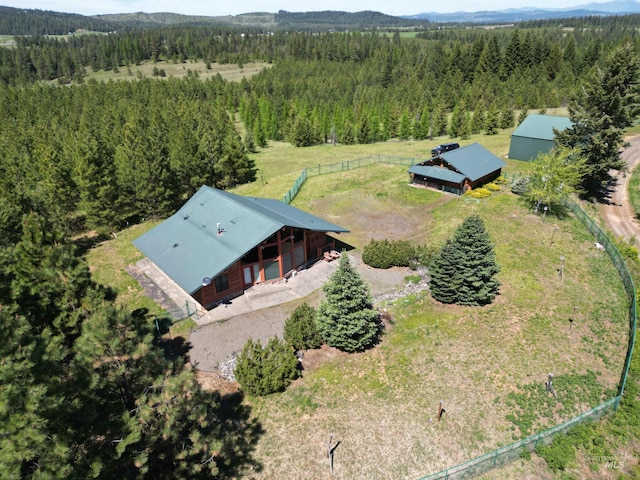 aerial view of property and surrounding area with a heavily wooded area