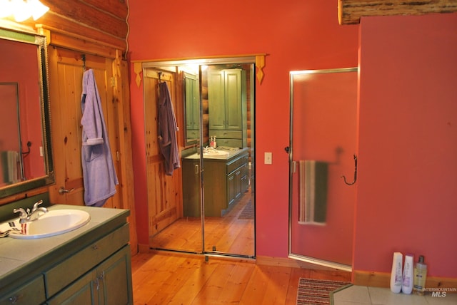 bathroom featuring wood-type flooring, vanity, and baseboards
