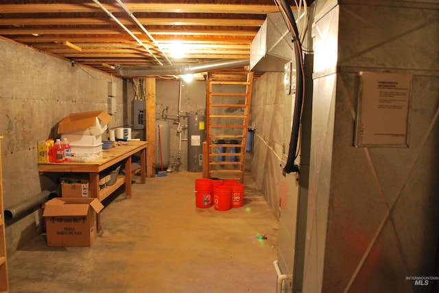 unfinished below grade area featuring water heater and a water pressure tank