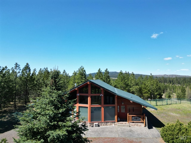 view of front of property featuring fence and a view of trees