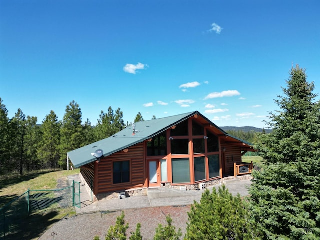 rear view of property featuring fence and log veneer siding