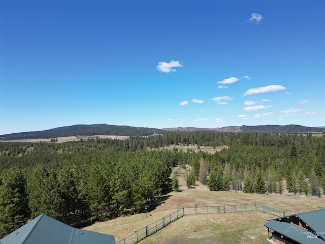 view of mountain backdrop with a heavily wooded area