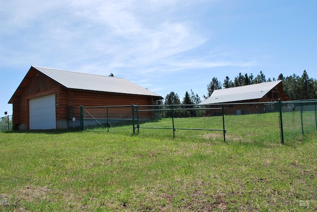 view of yard featuring a garage and an outbuilding