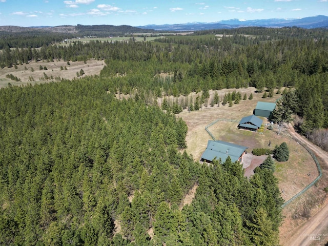 view of property location featuring a heavily wooded area and a mountainous background