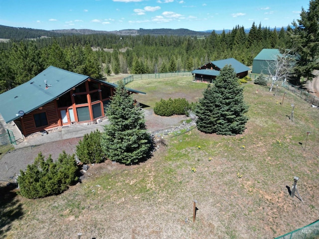 aerial view of property and surrounding area featuring a heavily wooded area