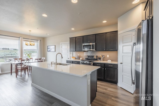 8228 S Bogus Ridge Ave, Boise, ID 83716 - kitchen featuring appliances with stainless steel finishes, a sink, wood finished floors, decorative backsplash, and recessed lighting