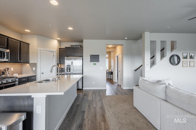 8228 S Bogus Ridge Ave, Boise, ID 83716 - kitchen featuring appliances with stainless steel finishes, a sink, dark wood finished floors, dark brown cabinetry, and open floor plan
