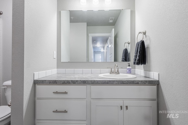 8228 S Bogus Ridge Ave, Boise, ID 83716 - bathroom with a textured wall, vanity, and toilet