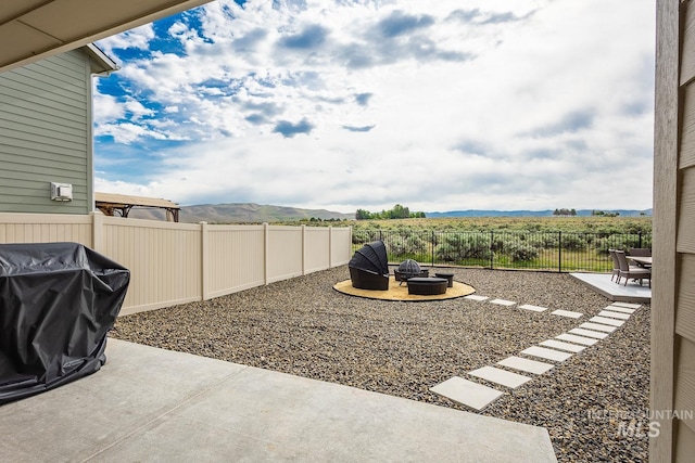 8228 S Bogus Ridge Ave, Boise, ID 83716 - fenced backyard with a fire pit, a patio area, and a mountain view