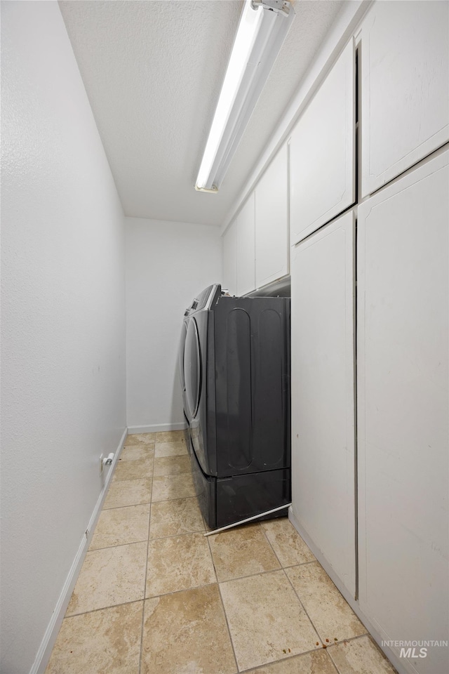 laundry area with baseboards, separate washer and dryer, and cabinet space