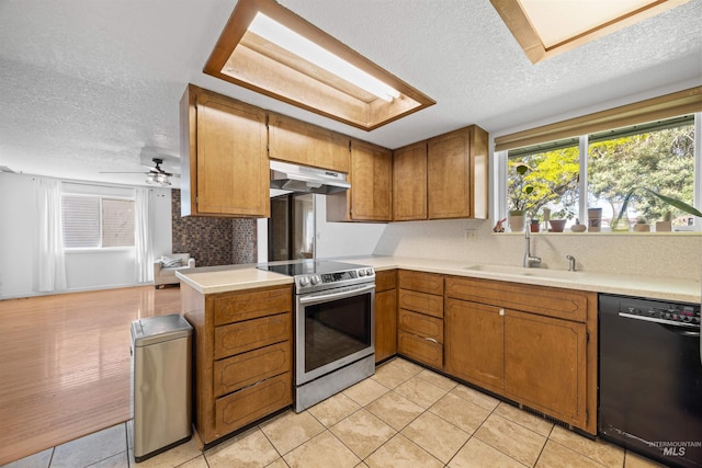 kitchen featuring a textured ceiling, under cabinet range hood, stainless steel electric stove, and dishwasher