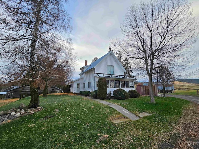 view of property exterior with a yard and a sunroom