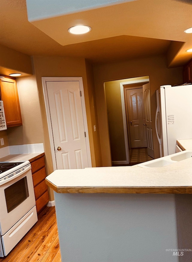 851 W Florida, Nampa, ID 83686 - kitchen with white appliances, a peninsula, light wood-style floors, light countertops, and a sink