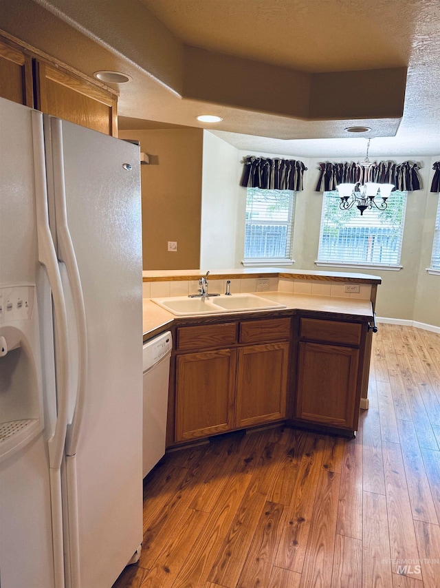 851 W Florida, Nampa, ID 83686 - kitchen with white appliances, a sink, a chandelier, brown cabinets, and plenty of natural light
