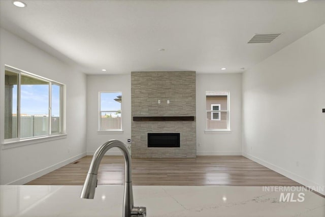 2158 N Kenora Ave, Star, ID 83669 - unfurnished living room with light wood-style flooring, recessed lighting, and a stone fireplace