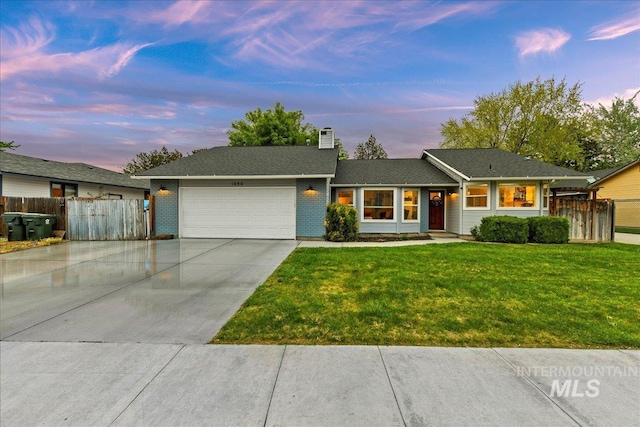 ranch-style home with concrete driveway, an attached garage, fence, and a front yard