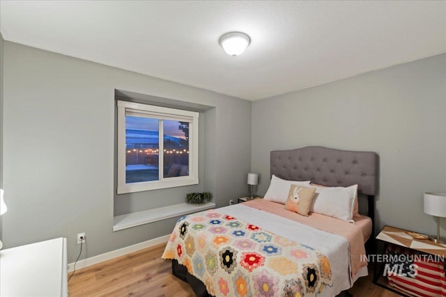 bedroom with baseboards and wood finished floors