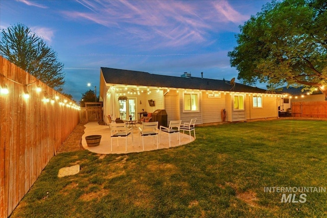 back of property featuring a lawn, a fenced backyard, and a patio area