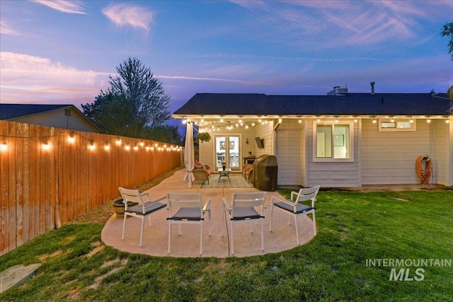 back of house with a fenced backyard, a patio, a yard, and french doors