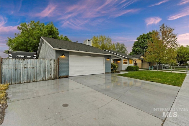 ranch-style home featuring an attached garage, fence, brick siding, and concrete driveway