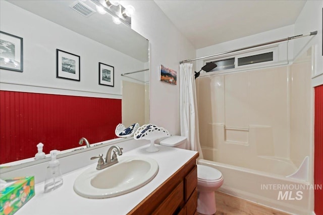 bathroom featuring visible vents, wood finished floors, vanity, toilet, and shower / bathtub combination with curtain