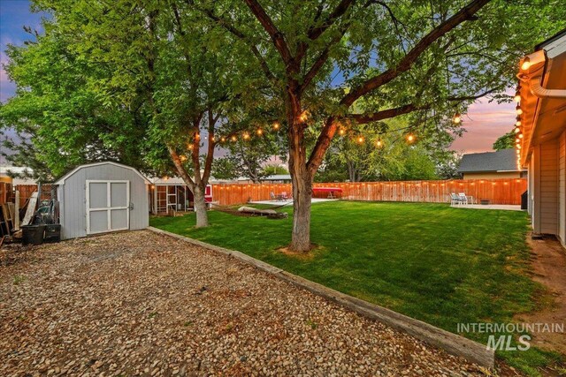 view of yard with a storage shed, an outdoor structure, and a fenced backyard
