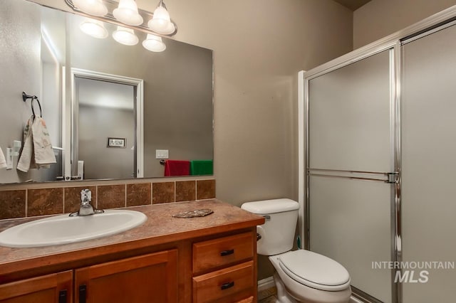 bathroom with vanity, toilet, an enclosed shower, and backsplash