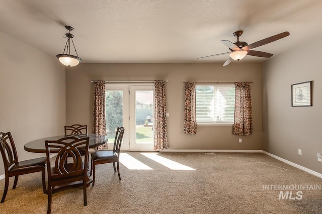 dining space featuring plenty of natural light, ceiling fan, and carpet