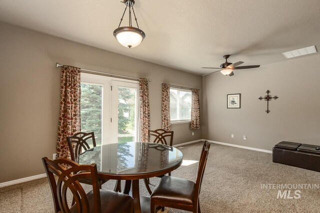 carpeted dining space with ceiling fan