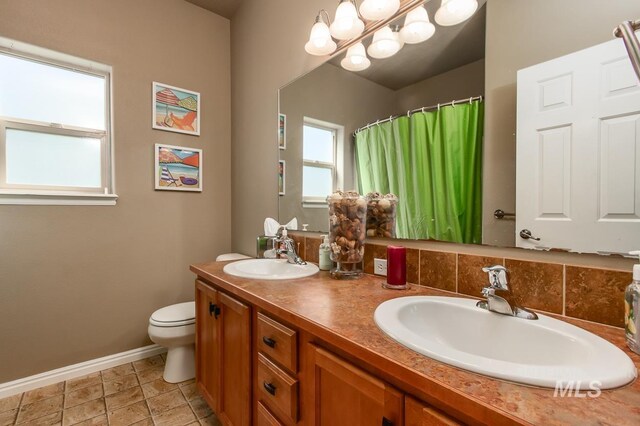 bathroom with vanity, toilet, tile patterned floors, and tasteful backsplash