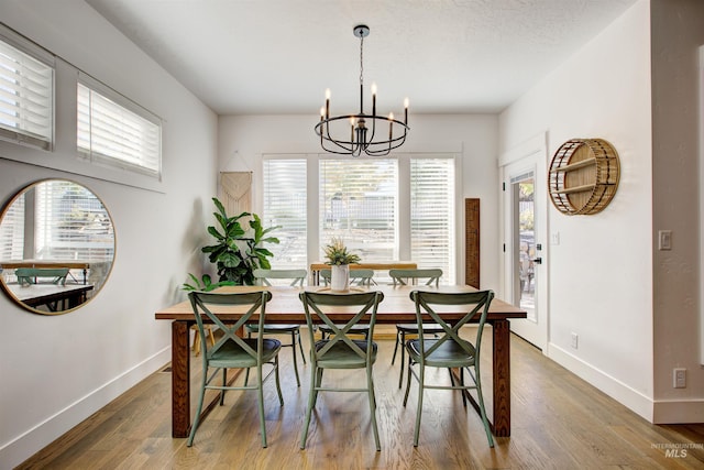 dining space featuring hardwood / wood-style floors and a chandelier