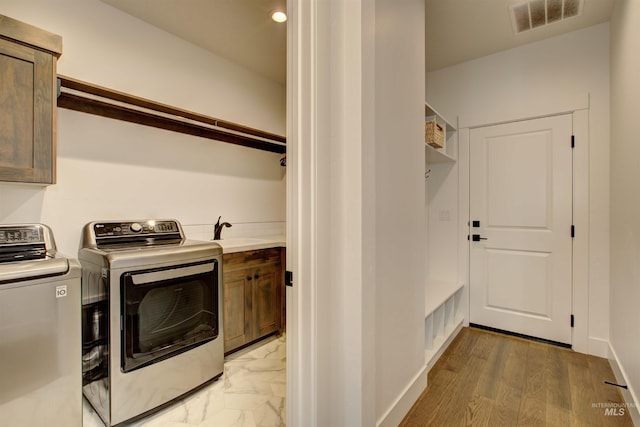 laundry room with washer and dryer, sink, and cabinets