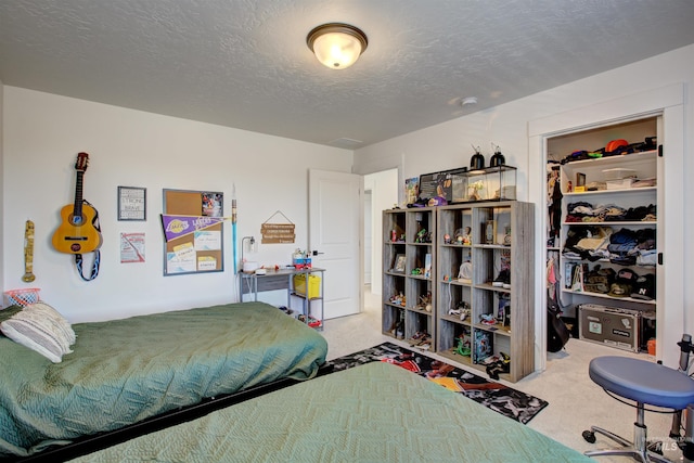 bedroom featuring a textured ceiling and light colored carpet