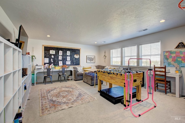 playroom featuring a textured ceiling and carpet floors