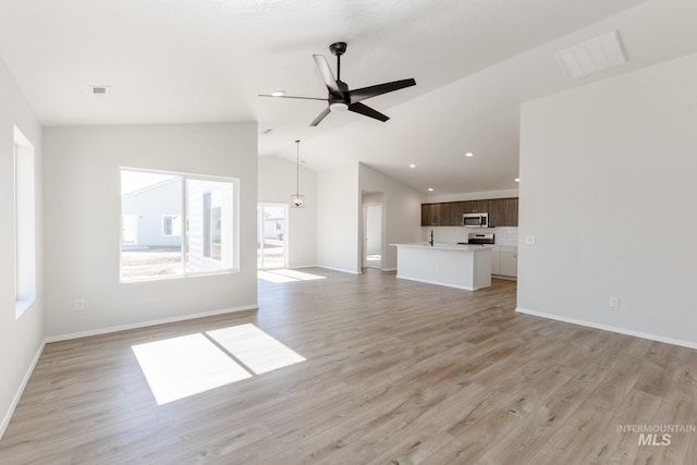 unfurnished living room with lofted ceiling, baseboards, light wood finished floors, and visible vents