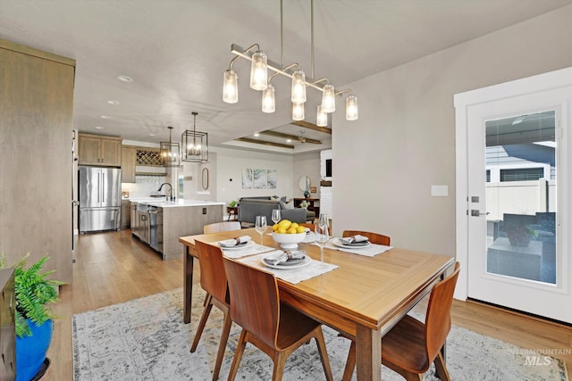 dining room with light wood finished floors and an inviting chandelier