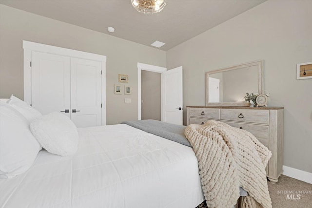 bedroom with light carpet, baseboards, and a closet