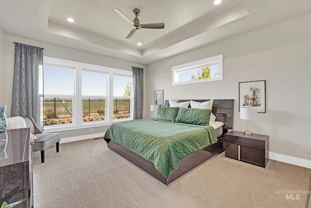bedroom featuring a tray ceiling, carpet flooring, baseboards, and recessed lighting